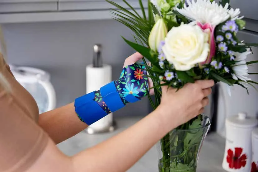 Tutore blu con stampa floreale mentre si sistema un mazzo di fiori
